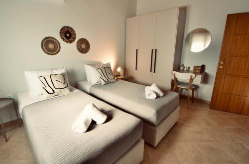 a bedroom with two beds with white towels on them at Enalio Beach House in Nea Kallikrateia