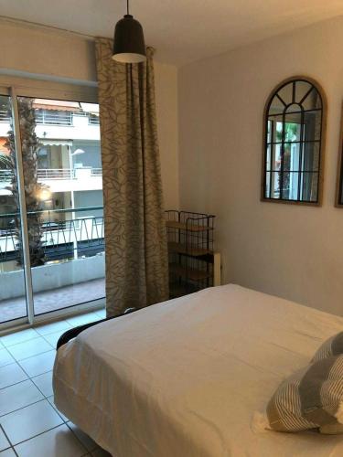 une chambre avec un lit et une grande fenêtre dans l'établissement Flat in Juan, à Antibes