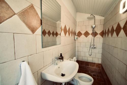 a bathroom with a sink and a toilet at Enalio Beach House in Nea Kallikrateia