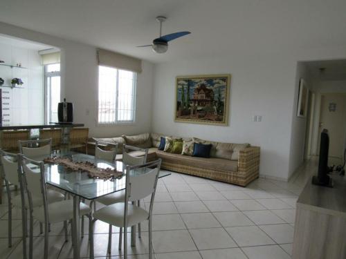 a living room with a couch and a table and chairs at Luz do Sol Pinheira in Pinheiro