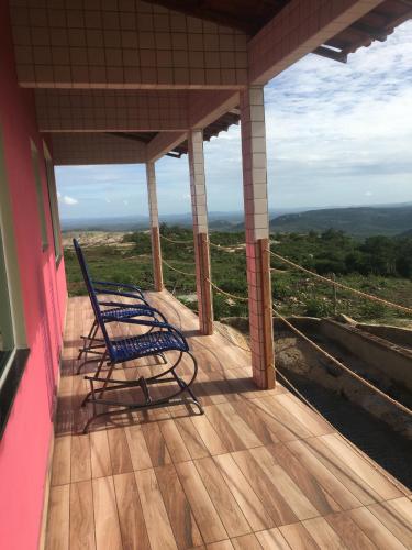 a rocking chair sitting on the porch of a house at Chalé Pedro & Carmelita in Serra de São Bento