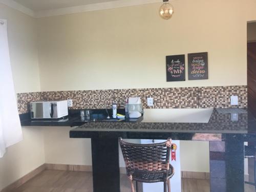 a kitchen with a counter and a chair in a room at Chalé Pedro & Carmelita in Serra de São Bento