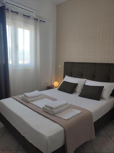1 dormitorio con 1 cama grande con sábanas y almohadas blancas en Olive House, en Moírai