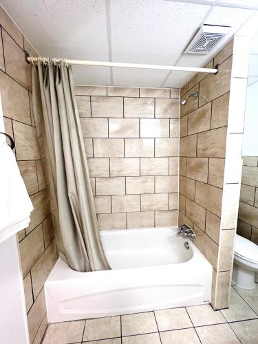 a bathroom with a tub and a toilet at Fairway Inn by the Falls in Niagara Falls