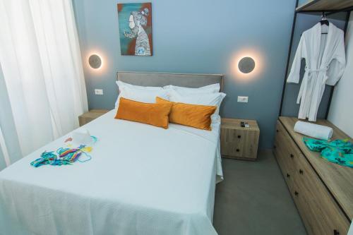 a bedroom with a large white bed with orange pillows at Ialemos Group in Symi