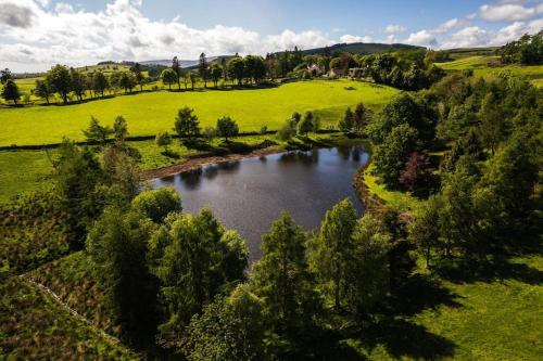 an aerial view of a river in a field at Spacious & Stylish StoneHous Cottage in Forfar