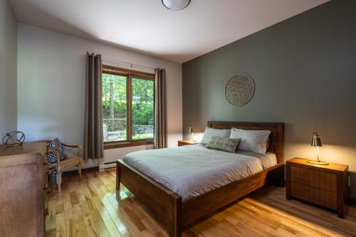 a bedroom with a large bed and a window at Le Boisé (Les Manoirs) Mont-Tremblant in Mont-Tremblant