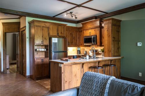 a kitchen with wooden cabinets and a counter top at Le Boisé (Les Manoirs) Mont-Tremblant in Mont-Tremblant