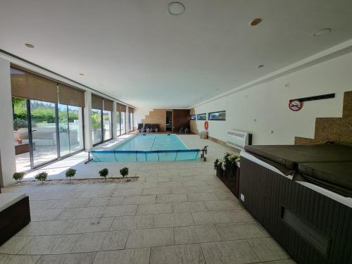 a large room with a swimming pool in a building at Villa Amor in Touguinho