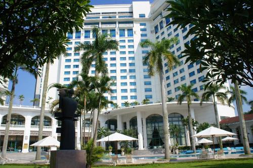 a large building with palm trees in front of it at Daeha Serviced Apartment in Hanoi