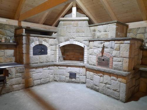 a large stone oven in a room with a wooden ceiling at Penzion Na Farmě in Karle