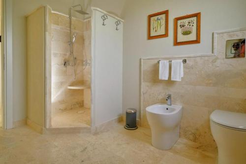 een badkamer met een douche, een toilet en een wastafel bij Corte dei Mirti, camere signorili in Iglesias