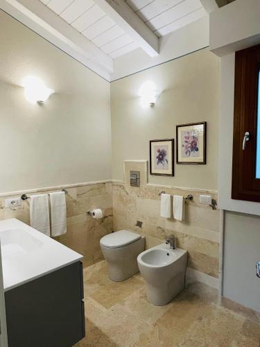 a bathroom with a toilet and a sink at Corte dei Mirti, camere signorili in Iglesias