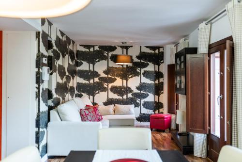 a living room with a white couch and a wall at Precioso apartamento en el centro de Granada in Granada