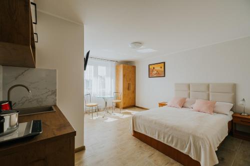 Un dormitorio con una cama con almohadas rosas. en FAMILKA en Karwia