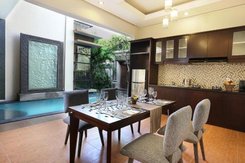 a kitchen and dining room with a table and chairs at Argya Santi Suite and Villas in Seminyak