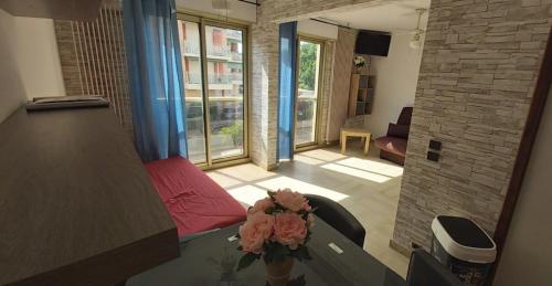 un salon avec une table avec un vase de fleurs dans l'établissement Vacances piscine à HYERES LES PALMIERS 1er etage, à Hyères