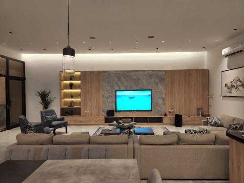 ein Wohnzimmer mit Sofas und einem Flachbild-TV in der Unterkunft شاليه فاخر جداً جداً وخاص in Riad