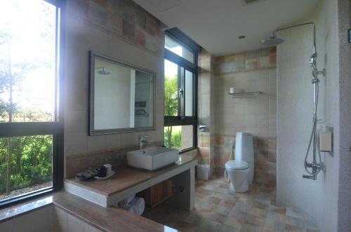 a bathroom with a sink and a toilet and a mirror at Full Sweet Inn in Wujie