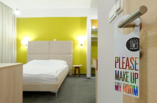 a room with a bed and a sign on a wall at Hotel Tim's in Skopje