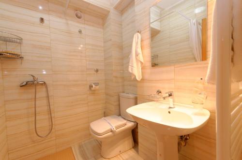 a bathroom with a sink and a toilet and a shower at Hotel Tim's in Skopje