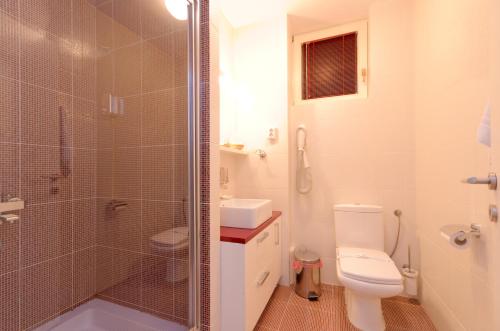 a bathroom with a toilet and a glass shower at Hotel Tim's in Skopje