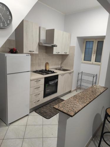 eine Küche mit weißen Geräten und einer Arbeitsplatte in der Unterkunft Casa Cindy in Lamezia Terme