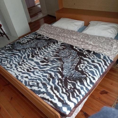 um cobertor de estampa de zebra numa cama num quarto em Apartman Biljana em Berovo