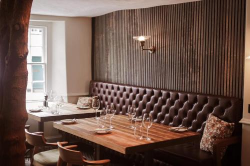 a dining room with a long table with wine glasses at Royal Oak Hotel in Rosthwaite