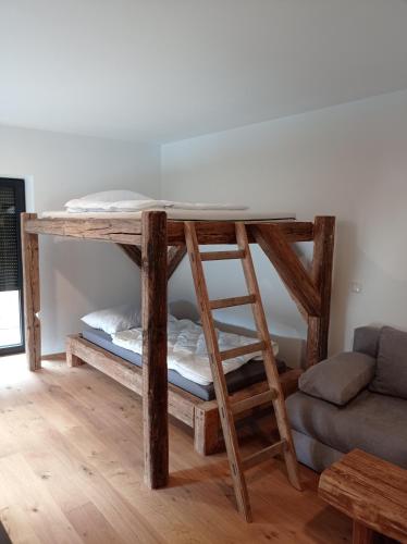 a wooden bunk bed in a room with a couch at Rittertal-Altholzseeblick in Altmünster