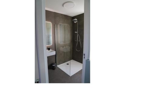 uma casa de banho com um chuveiro e um lavatório. em Chaletparc Krabbenkreek Zeeland - Chalet 232 em Sint Annaland