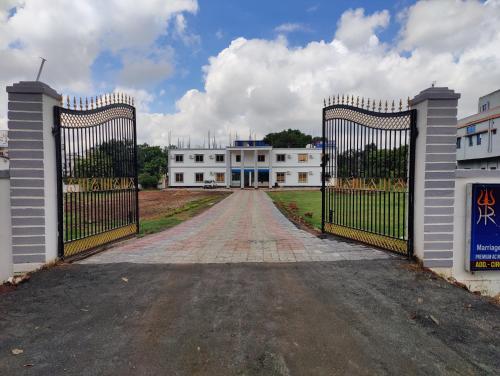 un cancello aperto per un grande edificio bianco di HR Garden(Hotel & Resort) a Deoghar