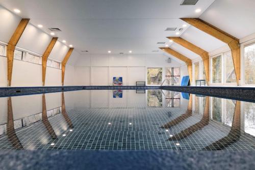 an indoor swimming pool with a swimming floor and windows at Oui-Durbuy in Durbuy