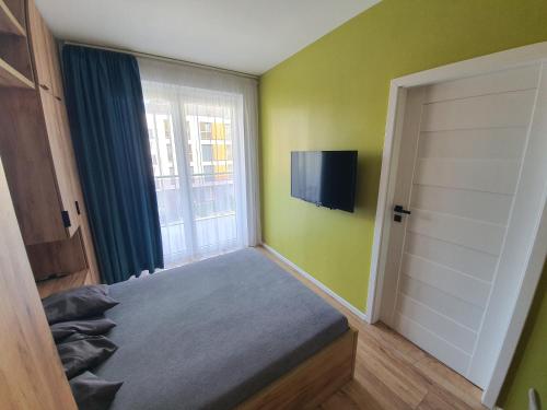 ein Schlafzimmer mit einem Bett und einem TV an der Wand in der Unterkunft Apartament 24 in Mysłowice
