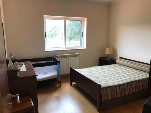 a bedroom with a bed and a desk and a window at Casa dos Copins in Lamego