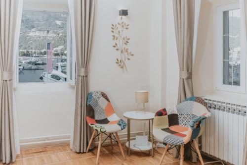 a room with two chairs and a table and a window at Regina apartments in Budva