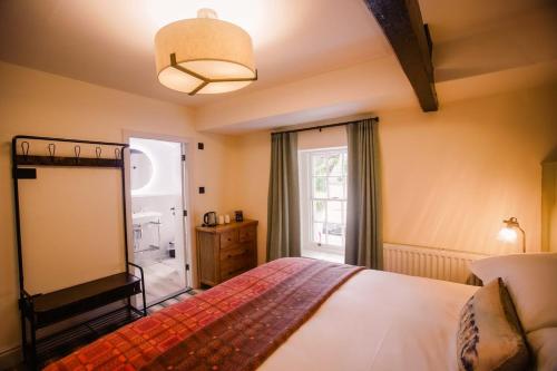 a bedroom with a bed and a large window at Royal Oak Hotel in Rosthwaite