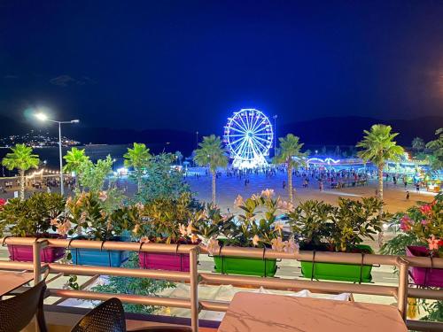 a view of a beach at night with a ferris wheel at Veranda Boutique Hotel in Vlorë
