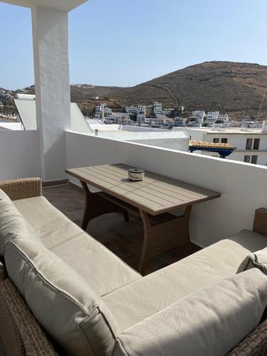 einen Balkon mit einem Holztisch und Stühlen in der Unterkunft Aegean Breeze Kythnos Greek small apartment in Mérikhas