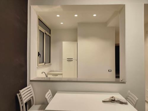 a kitchen with a white table and a mirror at Fantasia B&B APARTAMENT STUDIO in Pellaro
