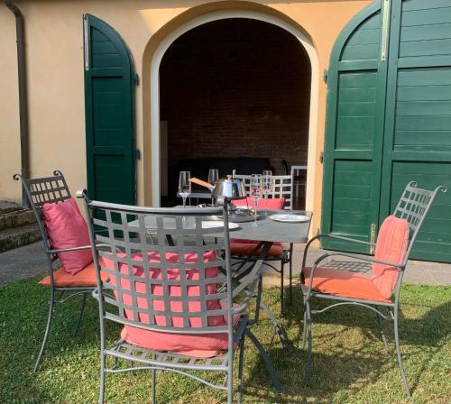 a table and four chairs with a table and green doors at Incantevole borgo con piscine in Colleoli