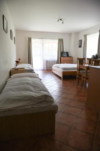 a bedroom with two beds and a table and chairs at Penzion U Skutilů in Pilníkov
