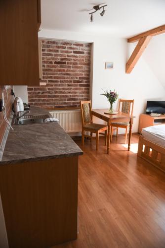 a kitchen and living room with a table and chairs at Penzion U Skutilů in Pilníkov