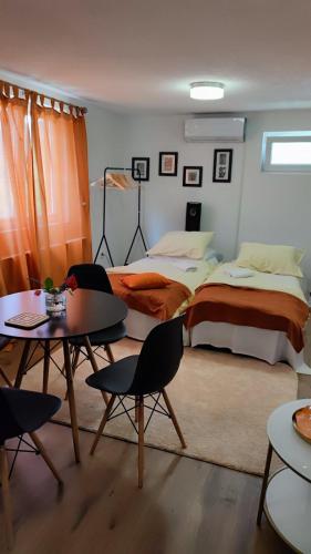 a bedroom with a bed and a table and chairs at Dream Home Studio Apartments in Tuzla