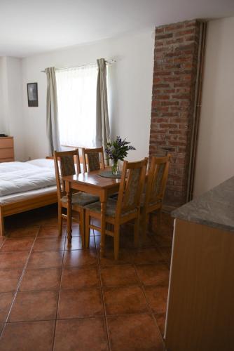 a dining room with a table and chairs and a bed at Penzion U Skutilů in Pilníkov