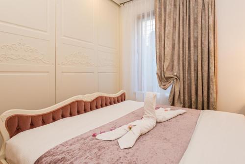 a bedroom with a bed with two pairs of shoes on it at Gintarinė KOPA in Palanga