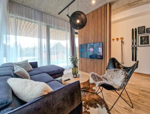 a living room with a blue couch and a chair at Apartmán STRÖMY Demänovská dolina in Liptovský Mikuláš