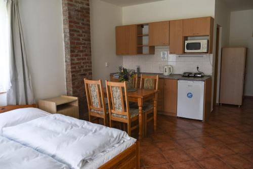 a kitchen with a bed and a table with chairs at Penzion U Skutilů in Pilníkov