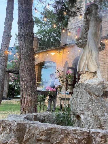 a statue of a woman sitting on a rock next to a tree at Hotel Lo Smeraldo in Roccavivara