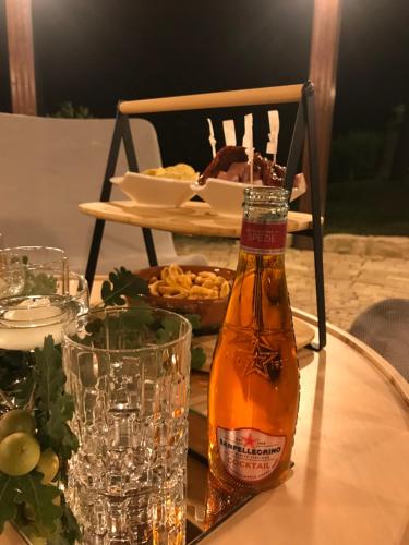a bottle of beer on a table with a plate of food at Hotel Lo Smeraldo in Roccavivara